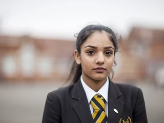 Secondary pupil in uniform looking at the camera.