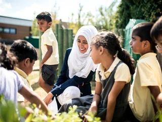 Teacher and students outside in the school garden in summertime