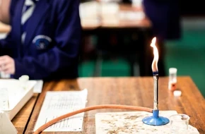 Bunsen burner on a desk in a classroom
