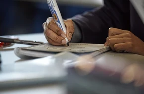 Image of pupil writing on mini whiteboard