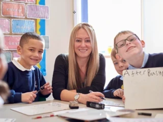 Female teacher smiling with primary school students
