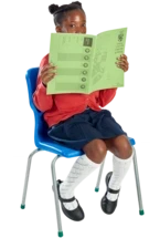 A seated schoolgirl peeks at the camera from behind an open exercise book. 